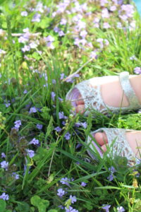 toddler toes in grass with spring blossoms